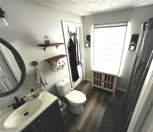 bathroom featuring vanity, a textured ceiling, wood finished floors, and toilet