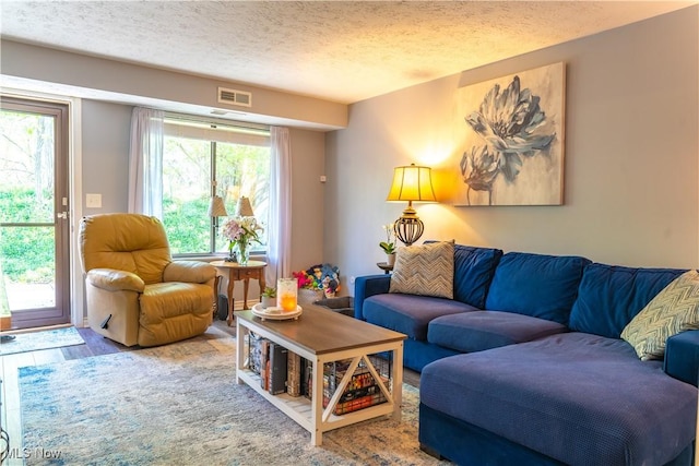 living room with visible vents and a textured ceiling