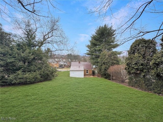 view of yard with fence, an outbuilding, and a storage shed
