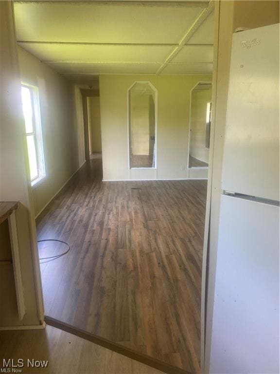 unfurnished room with baseboards and wood finished floors