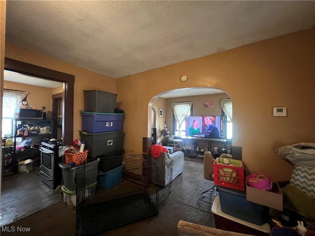 living room featuring arched walkways and a textured ceiling