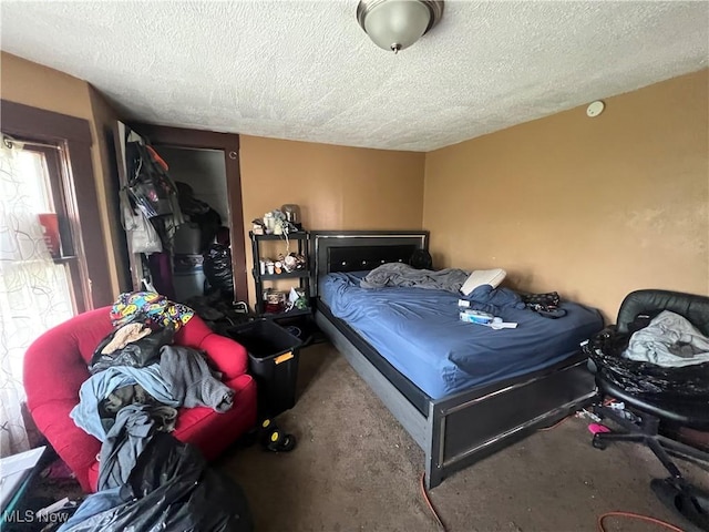 bedroom with carpet floors and a textured ceiling