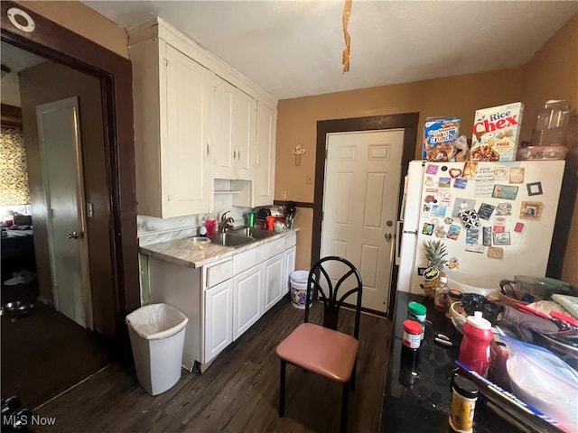 kitchen with freestanding refrigerator, white cabinetry, dark wood finished floors, and light countertops