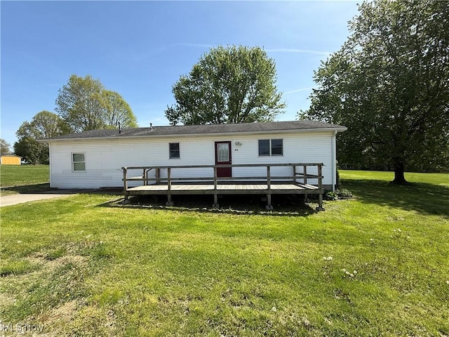 rear view of house featuring a lawn and a deck