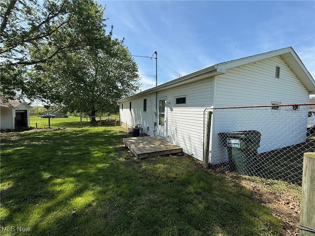 view of side of property featuring a lawn and fence