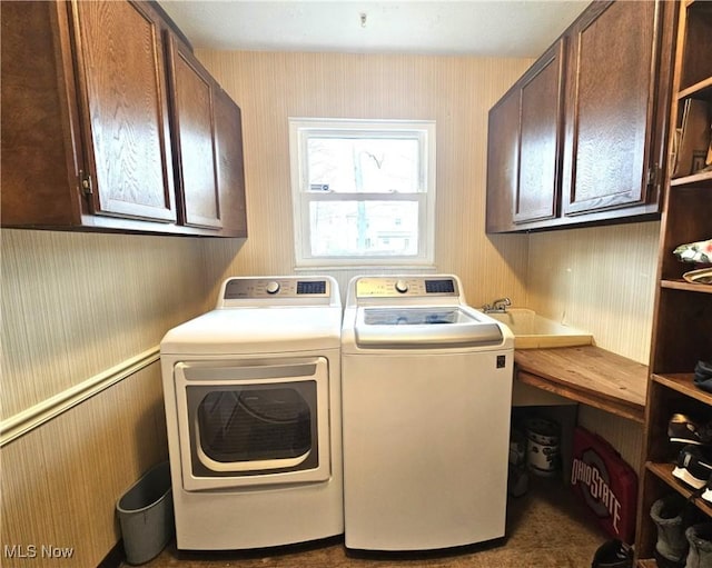 laundry area with cabinet space, wallpapered walls, and washer and dryer