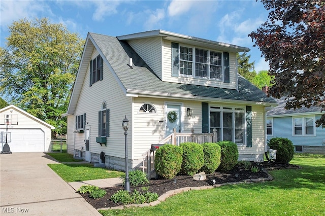 bungalow-style home featuring a garage, a front lawn, and an outbuilding