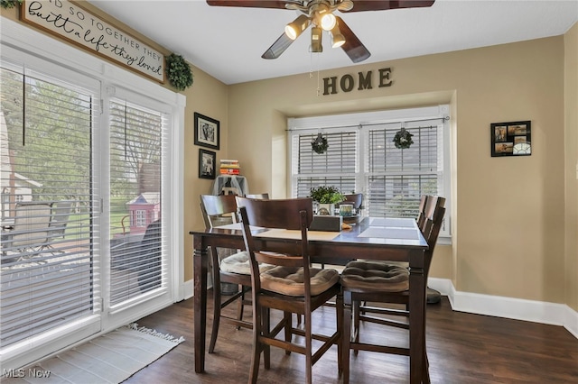 dining room featuring dark wood-style flooring, baseboards, and ceiling fan