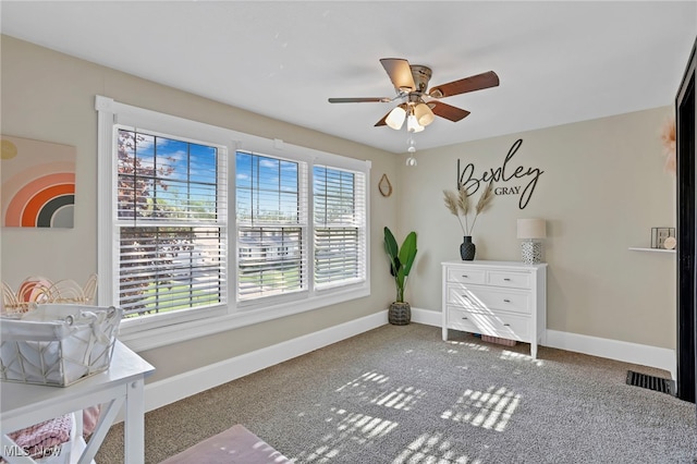 interior space featuring baseboards, ceiling fan, carpet floors, and visible vents