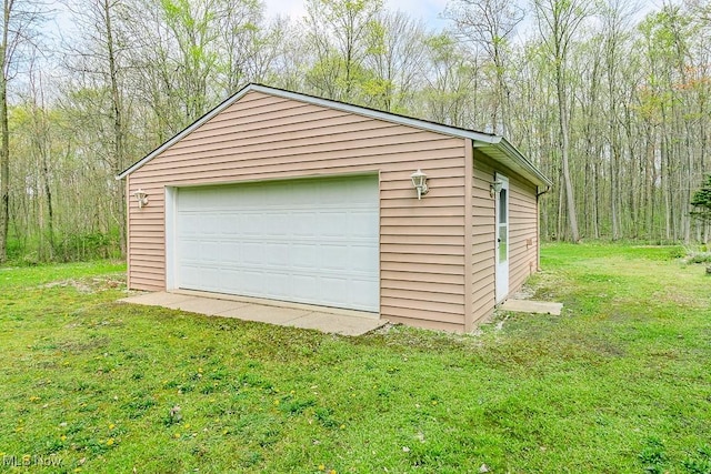 detached garage featuring a forest view