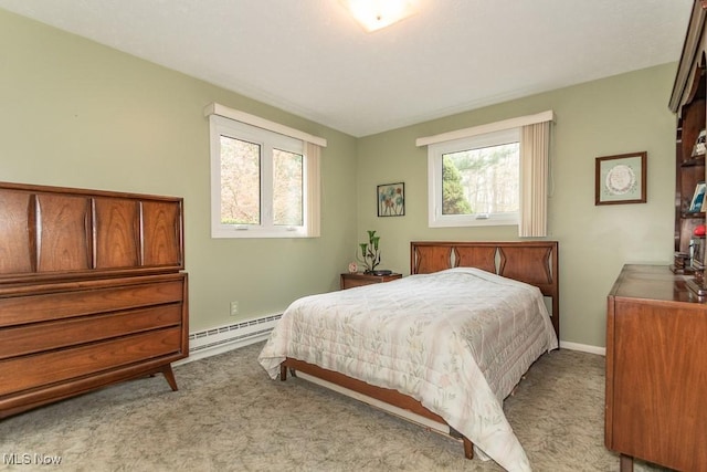 carpeted bedroom with baseboards and a baseboard heating unit