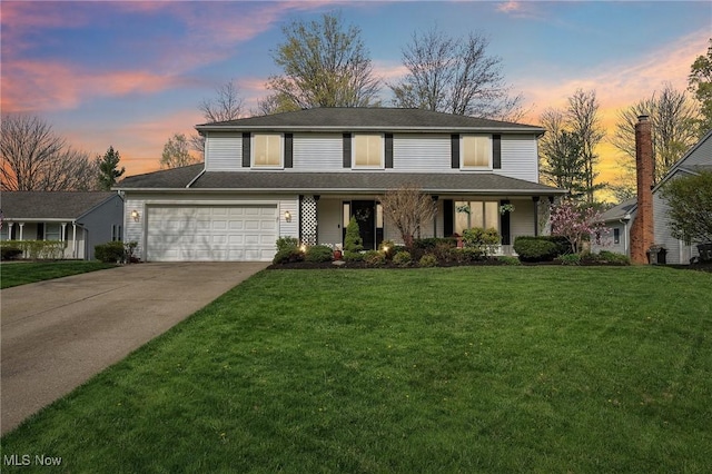 traditional home with a porch, an attached garage, driveway, and a front lawn