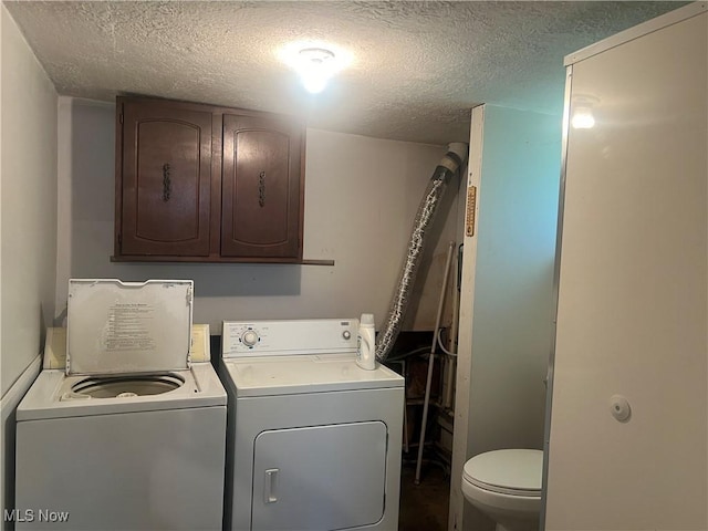 laundry room with a textured ceiling and washer and dryer