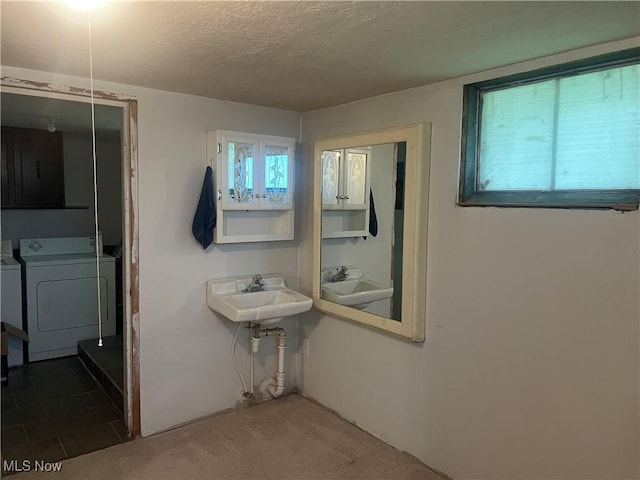 bathroom featuring a sink, a textured ceiling, and independent washer and dryer