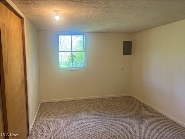 carpeted empty room with a textured ceiling, baseboards, and electric panel