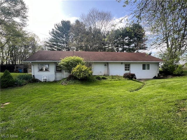 rear view of house featuring a yard