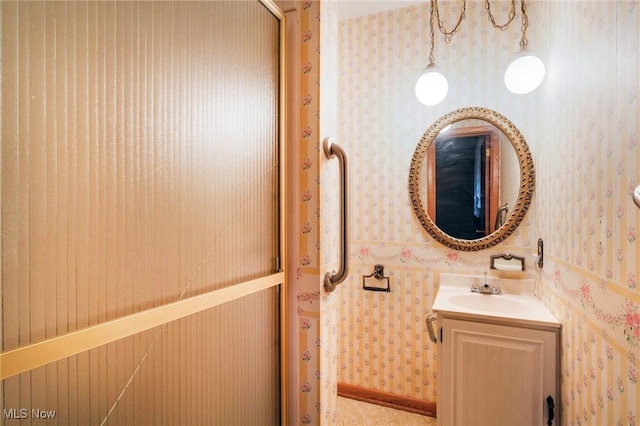 bathroom with wallpapered walls and vanity