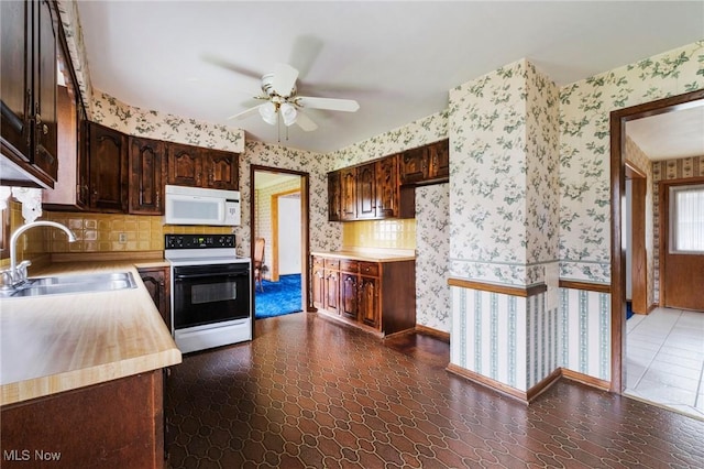kitchen with electric range, wallpapered walls, a sink, and white microwave