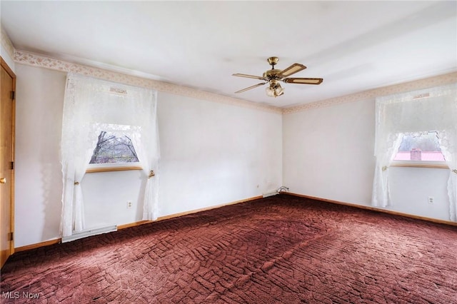 carpeted spare room with ceiling fan and baseboards
