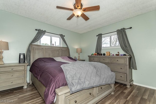 bedroom featuring baseboards, a textured ceiling, dark wood finished floors, and a ceiling fan