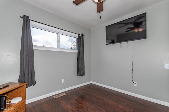 interior space with visible vents, a ceiling fan, baseboards, and wood finished floors
