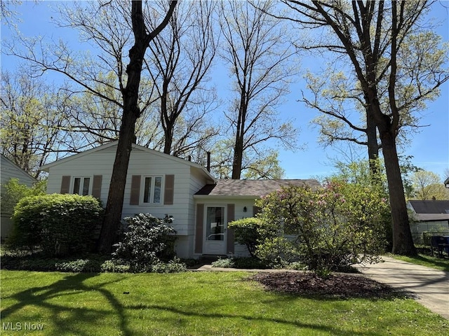 split level home with concrete driveway and a front yard