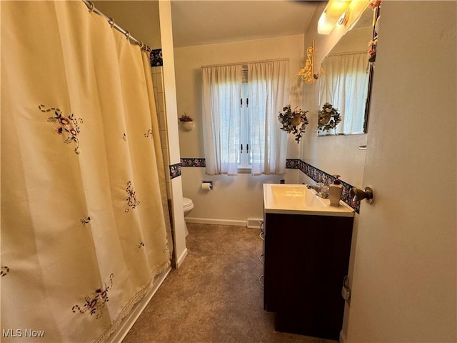 bathroom featuring vanity, baseboards, toilet, and curtained shower