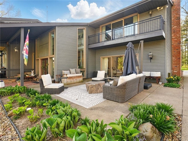 rear view of house featuring an outdoor living space, a patio area, and a balcony