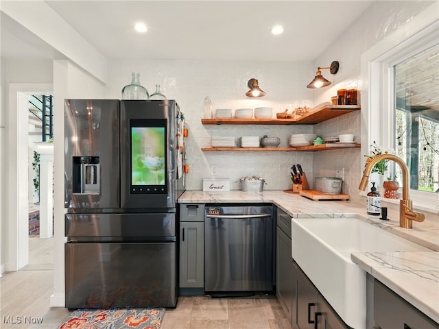 16165 Thompson Rd, Thompson, OH 44086 - kitchen featuring appliances with stainless steel finishes, a sink, light stone countertops, gray cabinetry, and backsplash