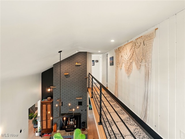 hallway featuring wood finished floors and lofted ceiling
