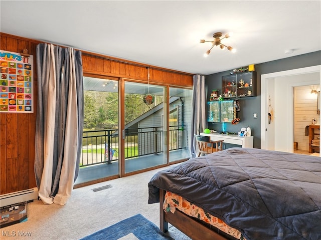 carpeted bedroom with visible vents, a baseboard radiator, wooden walls, and access to outside