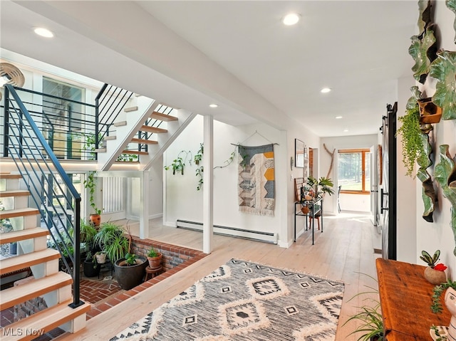 interior space with stairway, a baseboard radiator, recessed lighting, and light wood-style flooring