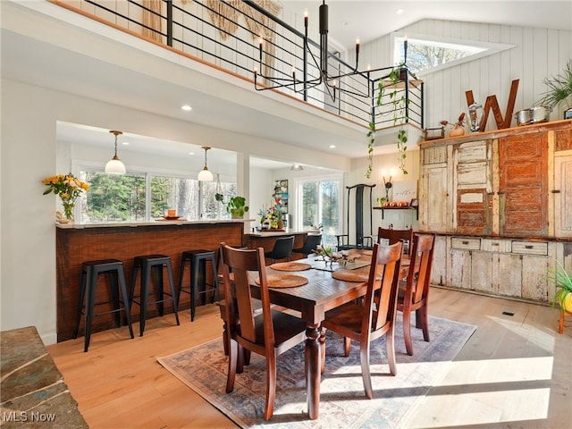 dining room with plenty of natural light, wood finished floors, and a towering ceiling