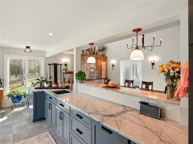 16165 Thompson Rd, Thompson, OH 44086 - kitchen with a sink, a peninsula, light stone counters, pendant lighting, and recessed lighting