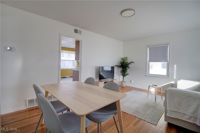 dining space featuring baseboards, visible vents, and wood finished floors