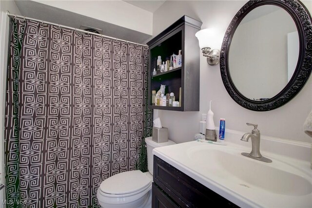 bathroom featuring toilet, a shower with curtain, and vanity
