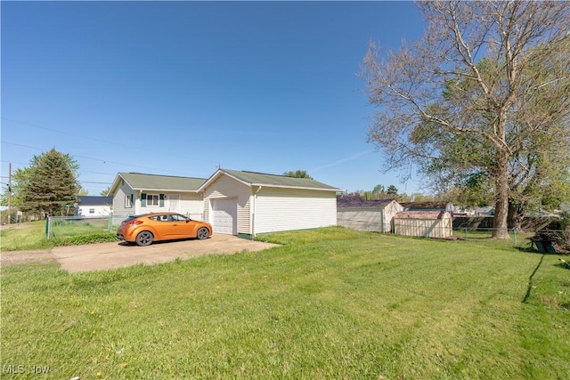 view of property exterior with an outdoor structure, fence, a yard, and concrete driveway