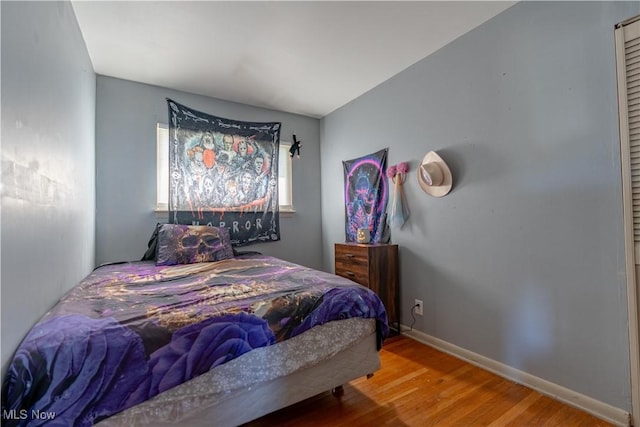 bedroom with baseboards and wood finished floors