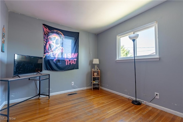 interior space featuring baseboards, wood finished floors, and visible vents