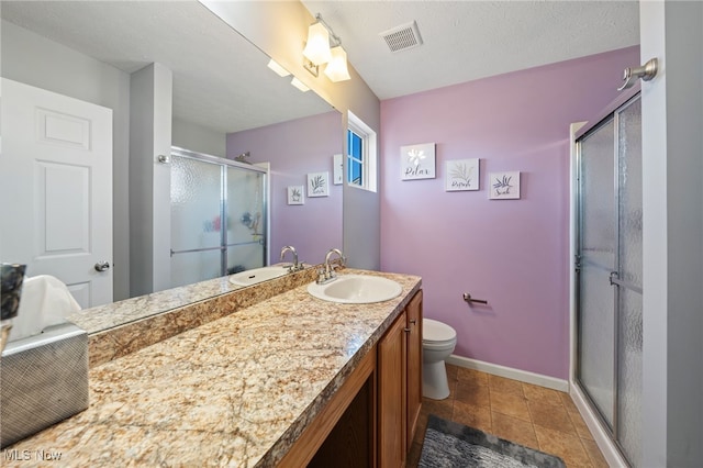 bathroom featuring vanity, toilet, baseboards, visible vents, and a stall shower