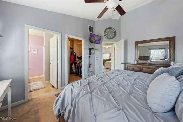 bedroom featuring light colored carpet, visible vents, baseboards, a spacious closet, and a closet