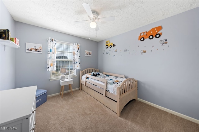 carpeted bedroom featuring a ceiling fan, a textured ceiling, and baseboards