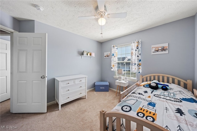 bedroom featuring baseboards, a ceiling fan, a textured ceiling, and light colored carpet