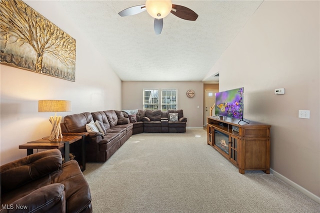 living area featuring ceiling fan, carpet, vaulted ceiling, and a textured ceiling