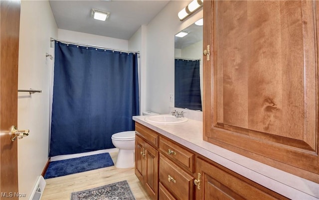 1423 N Wooster Ave, Dover, OH 44622 - bathroom featuring visible vents, wood finished floors, vanity, baseboards, and toilet
