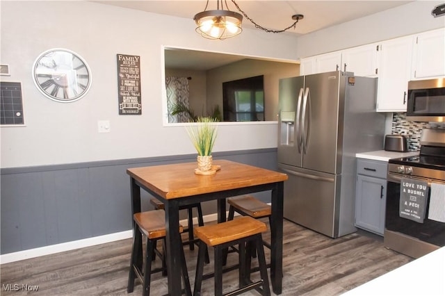 kitchen featuring white cabinets, tasteful backsplash, dark wood-style floors, and stainless steel appliances