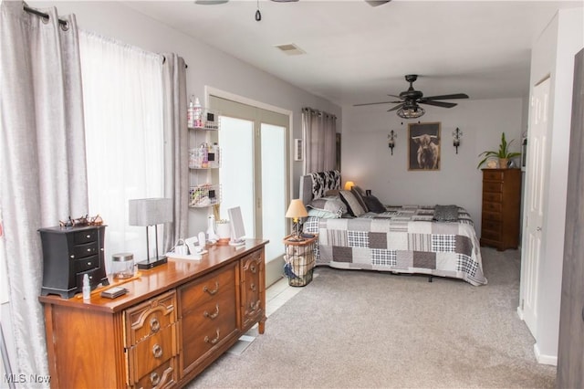 bedroom featuring visible vents, ceiling fan, and light carpet