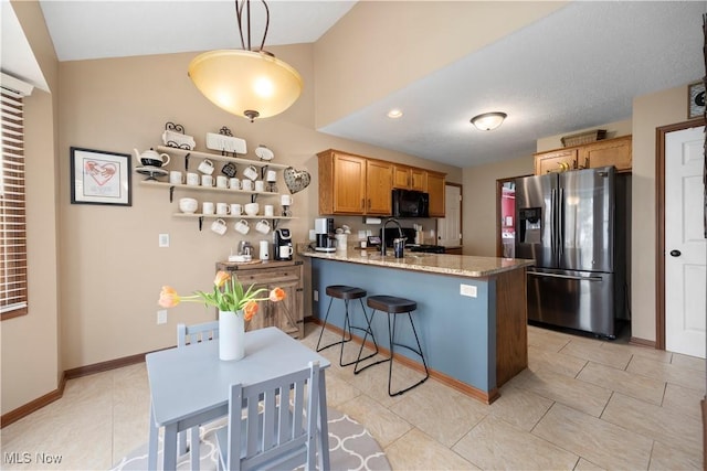 kitchen featuring black microwave, range, a peninsula, stainless steel refrigerator with ice dispenser, and vaulted ceiling