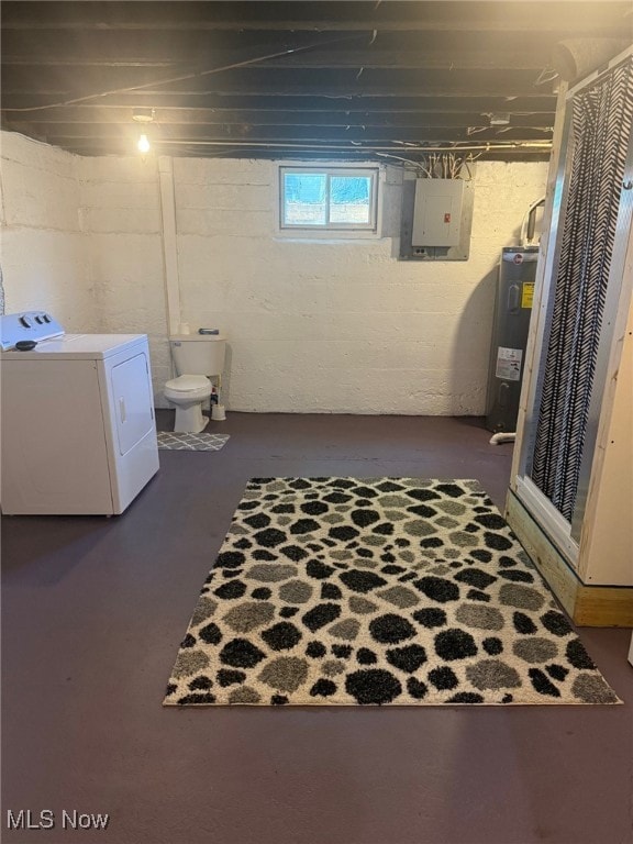 below grade area with washing machine and clothes dryer, electric panel, and electric water heater