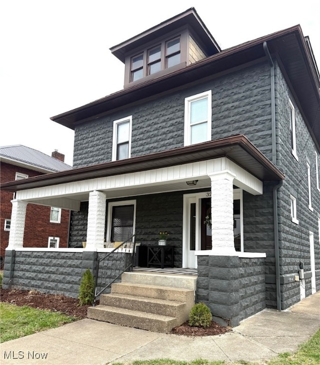 american foursquare style home with a porch
